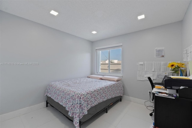 bedroom featuring light tile patterned floors and a textured ceiling