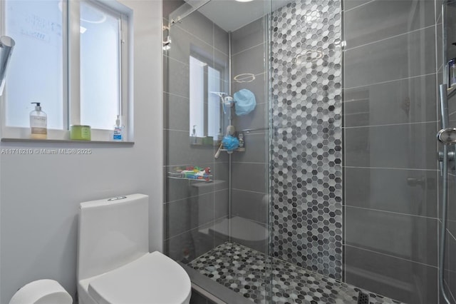 bathroom with tiled shower and toilet