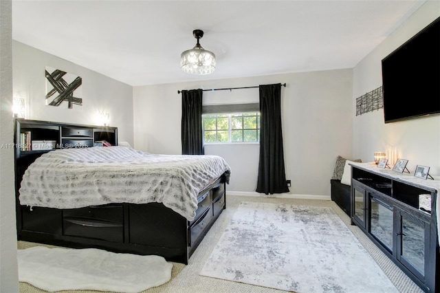 bedroom featuring light carpet and a notable chandelier