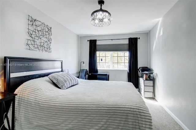 carpeted bedroom with an inviting chandelier