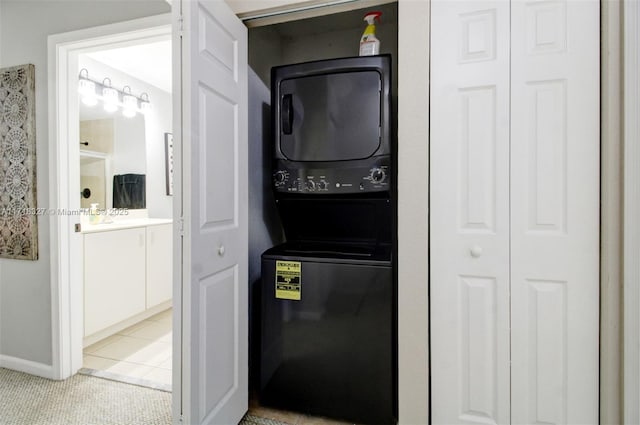 laundry room with stacked washer and clothes dryer and light tile patterned flooring