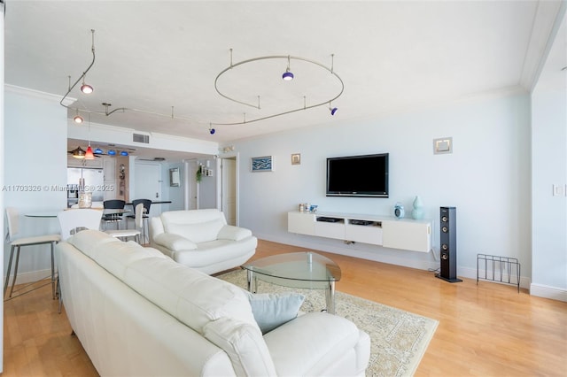 living room featuring light hardwood / wood-style flooring and crown molding