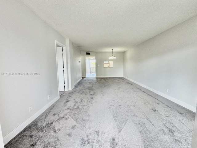 carpeted empty room featuring a textured ceiling