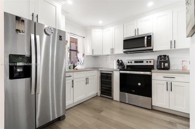 kitchen with white cabinets, sink, decorative backsplash, stainless steel appliances, and beverage cooler