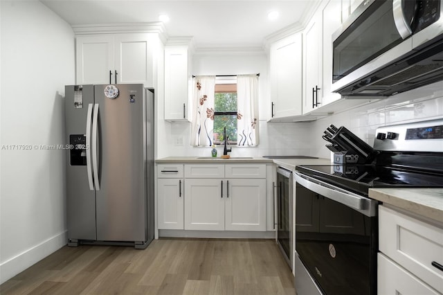 kitchen featuring sink, white cabinets, light hardwood / wood-style flooring, and appliances with stainless steel finishes