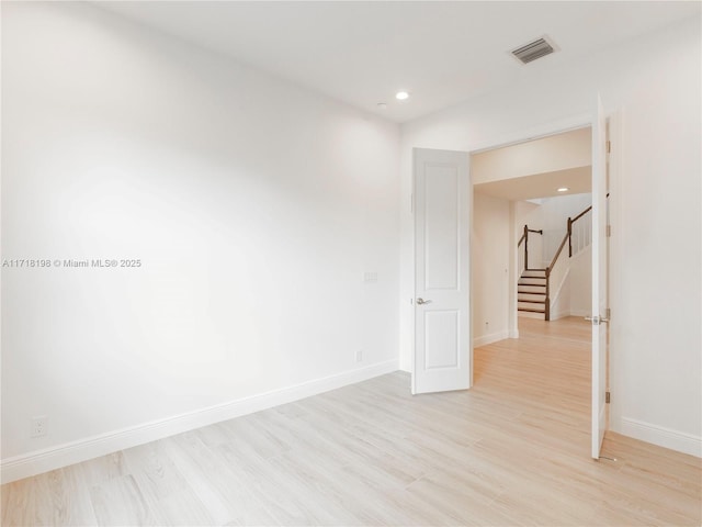 laundry room with light hardwood / wood-style floors, cabinets, and washing machine and clothes dryer