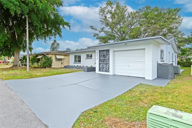 ranch-style home with a garage, a front yard, and central AC unit