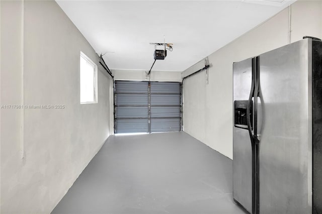 garage featuring stainless steel refrigerator with ice dispenser and a garage door opener