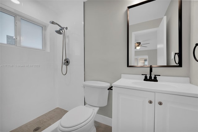 bathroom featuring ceiling fan, toilet, vanity, and tiled shower