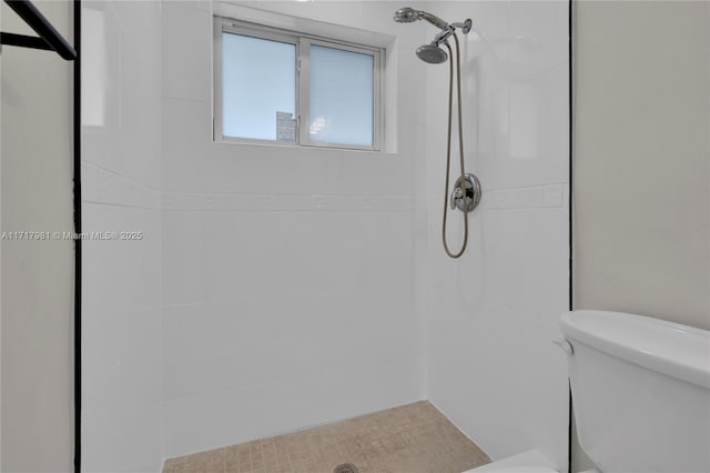 bathroom with toilet and tiled shower