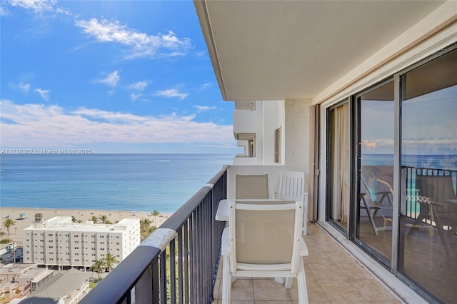 balcony featuring a beach view and a water view