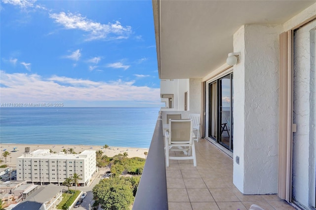 balcony featuring a view of the beach and a water view