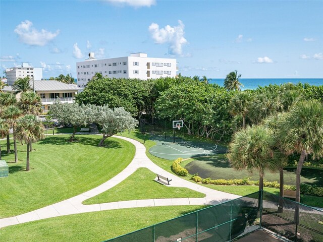 view of community featuring a lawn, a water view, and basketball court