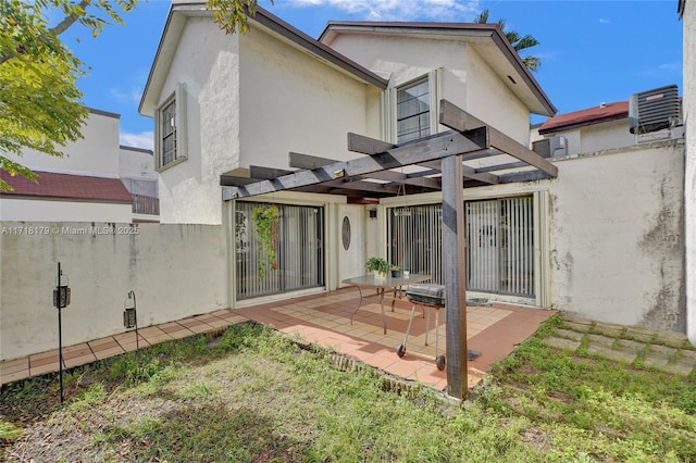 rear view of property featuring a pergola, central AC, a yard, and a patio