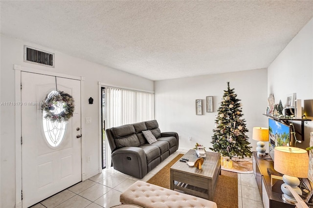 tiled living room featuring a textured ceiling