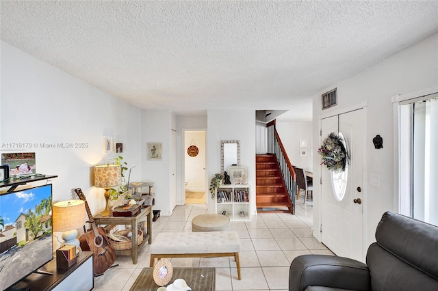 living room featuring a textured ceiling and light tile patterned flooring