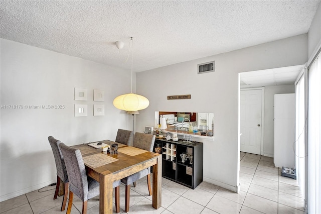 tiled dining area featuring a textured ceiling