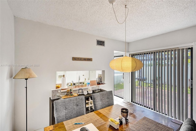 dining room with a textured ceiling, concrete floors, and sink