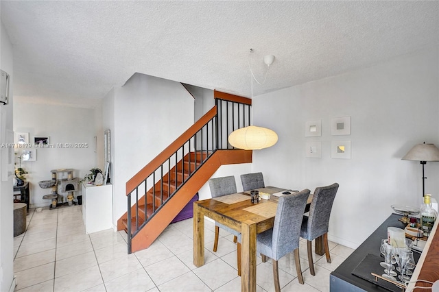 dining space with light tile patterned flooring and a textured ceiling