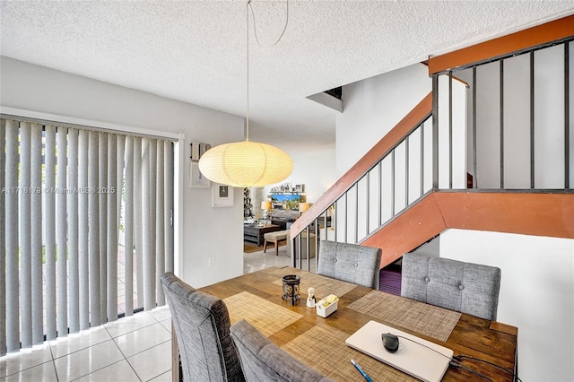 dining area featuring a textured ceiling and light tile patterned flooring