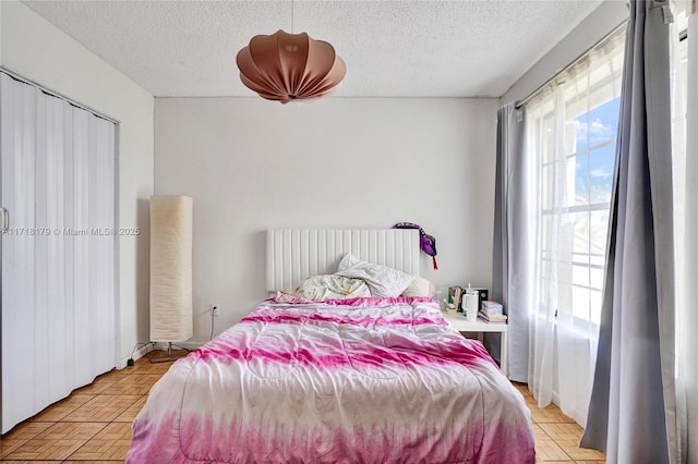 bedroom with a textured ceiling and light parquet flooring