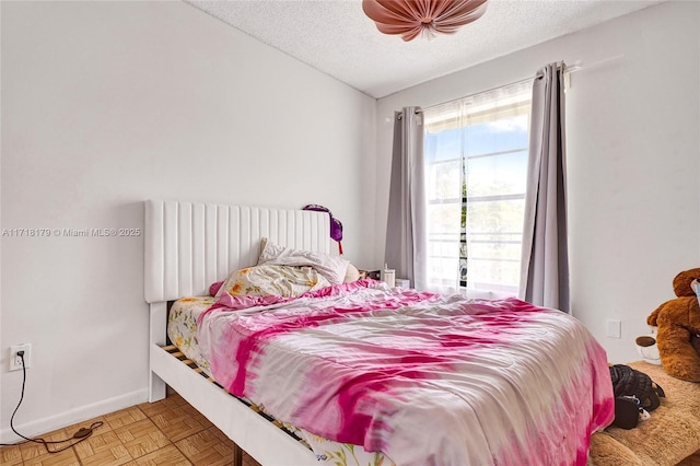 bedroom with parquet floors and a textured ceiling