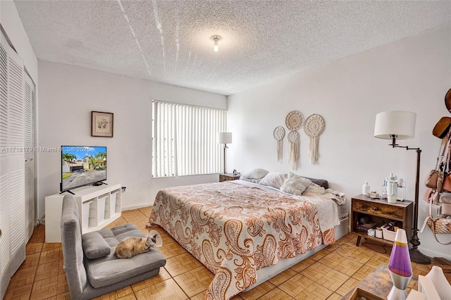 bedroom with light parquet floors and a textured ceiling