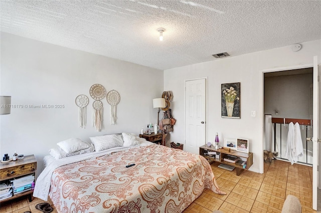 bedroom with a textured ceiling and light parquet flooring