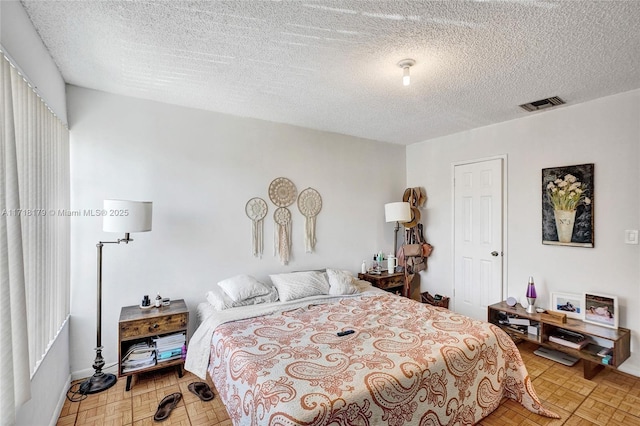 bedroom with a textured ceiling and light parquet floors