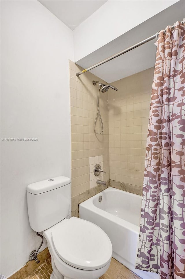 bathroom featuring tile patterned flooring, toilet, and shower / tub combo with curtain