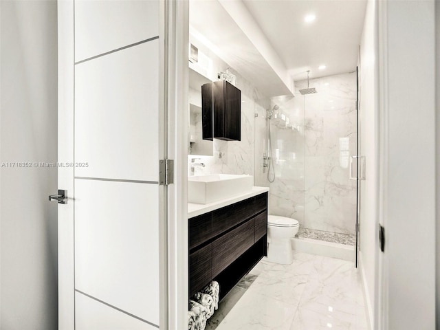 bathroom featuring vanity, a shower with shower door, and toilet