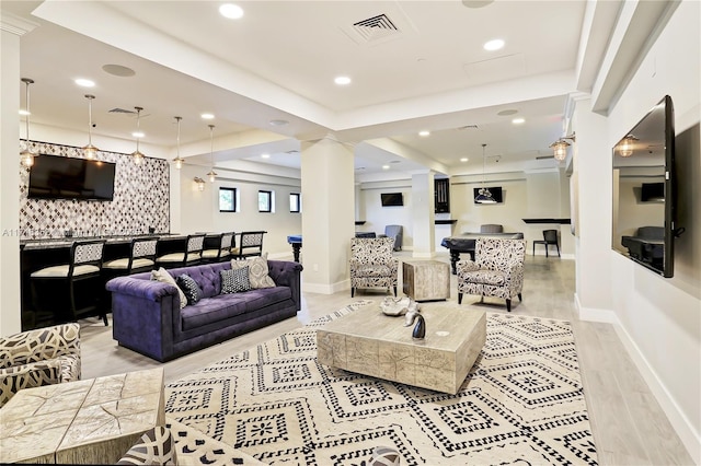 living room featuring decorative columns and light wood-type flooring