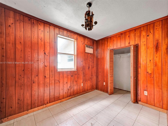 interior space featuring wooden walls and a textured ceiling