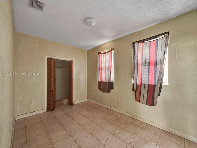 unfurnished bedroom featuring a textured ceiling and a closet