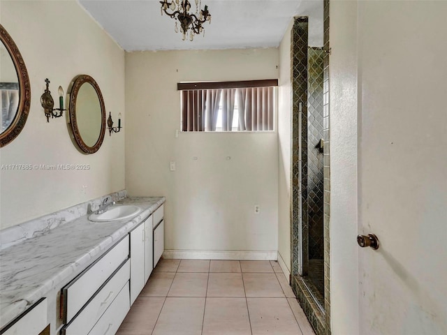 bathroom featuring tile patterned flooring, vanity, and a notable chandelier