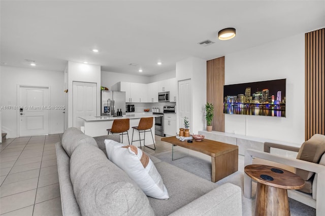 living area with light tile patterned floors, visible vents, and recessed lighting