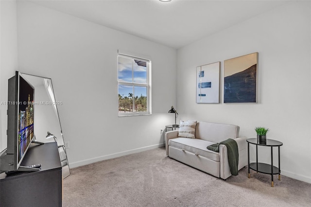 living area featuring light carpet and baseboards