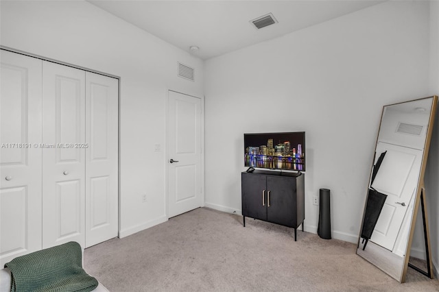 interior space featuring baseboards, visible vents, and light colored carpet