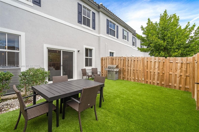 view of yard featuring outdoor dining space and fence