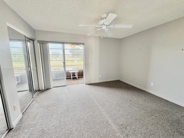 carpeted spare room featuring ceiling fan and a textured ceiling