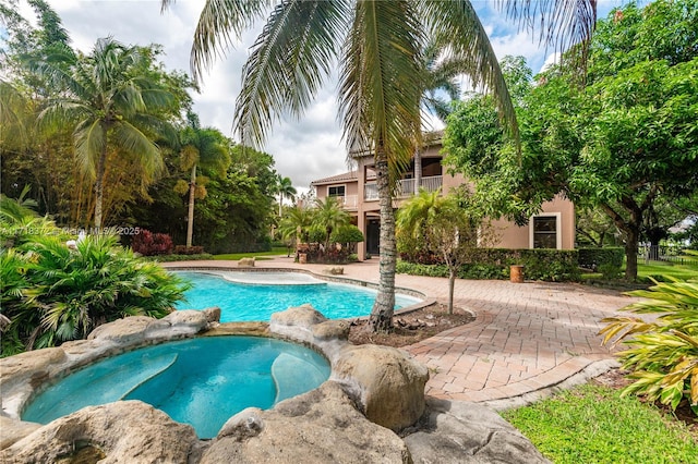 view of pool featuring an in ground hot tub