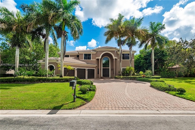 mediterranean / spanish-style house featuring a garage and a front lawn