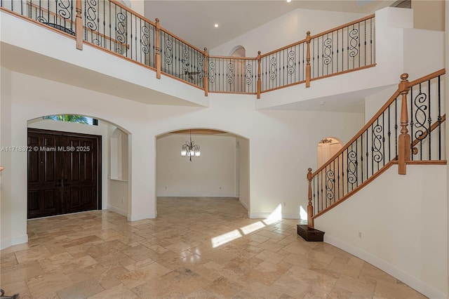 foyer with a towering ceiling and a notable chandelier