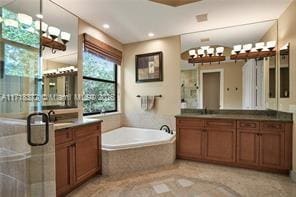 bathroom with separate shower and tub and vanity