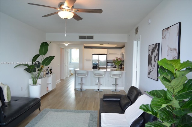 living room with light hardwood / wood-style floors and ceiling fan