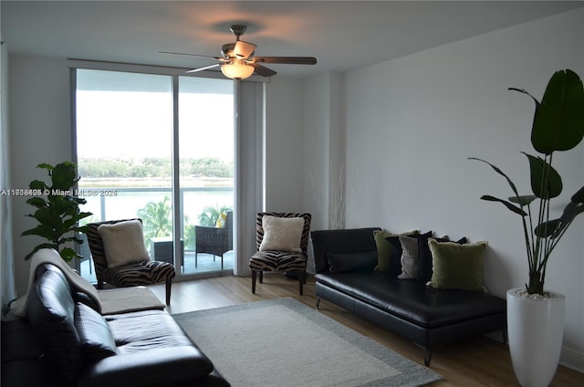 living room featuring ceiling fan, floor to ceiling windows, and light wood-type flooring