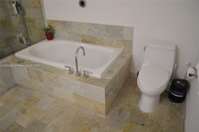 bathroom featuring tiled tub and toilet