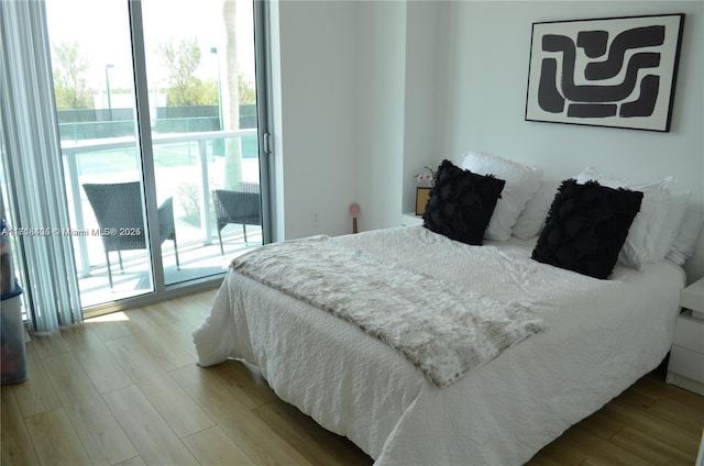 bedroom featuring light wood-type flooring and access to outside