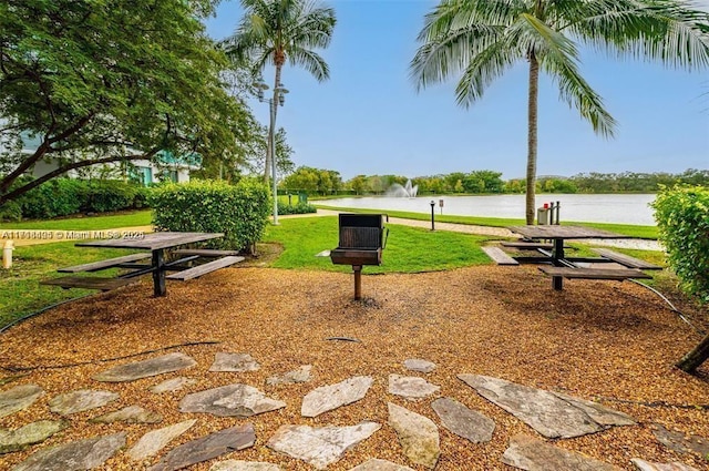 view of community featuring a lawn and a water view