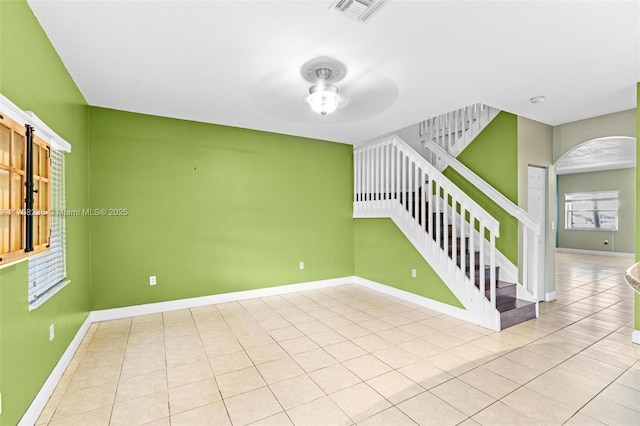 empty room with ceiling fan and light tile patterned floors